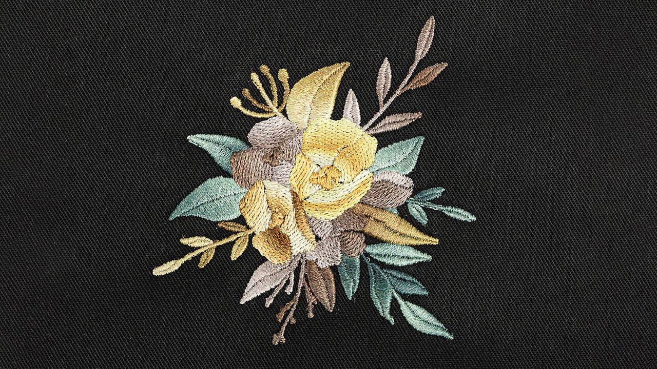 [Translate to Global Französisch:] Embroidery design of a flower with yellow, green and brown shade gradients 