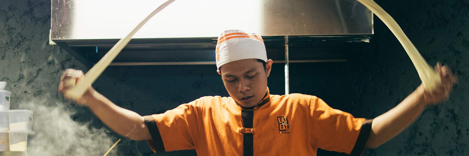 [Translate to Thailändisch:] Asian cook with embroidered working shirt