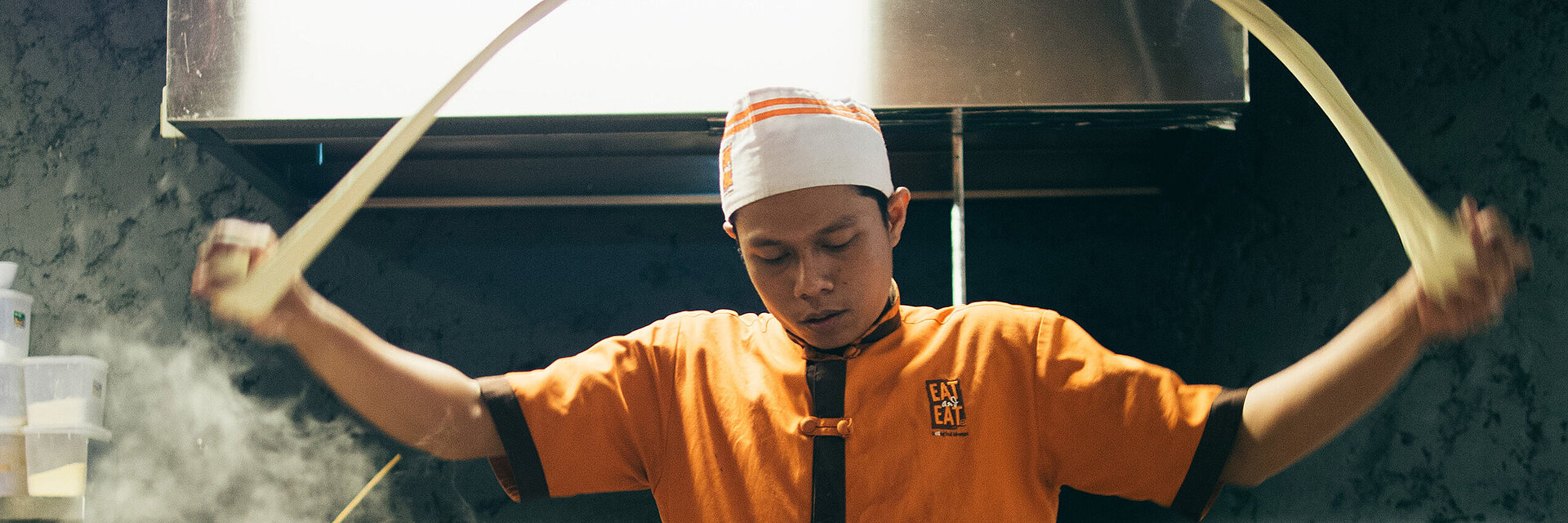 [Translate to Global Französisch:] Asian cook with embroidered working shirt
