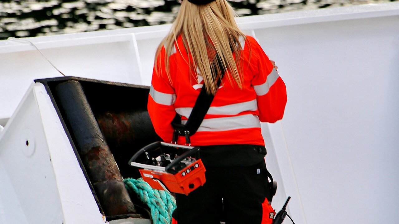 A person in a bright orange safety jacket against a white background