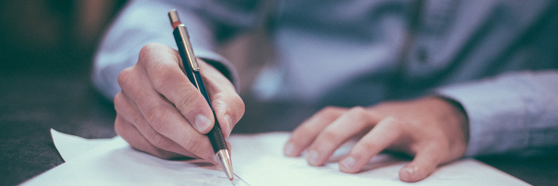 [Translate to Thailändisch:] Businessman writing on a paper