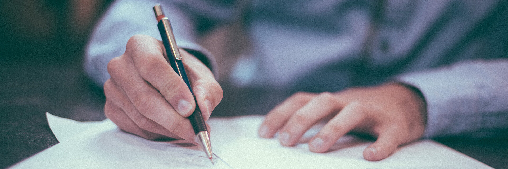 [Translate to Global Deutsch:] Businessman writing on a paper