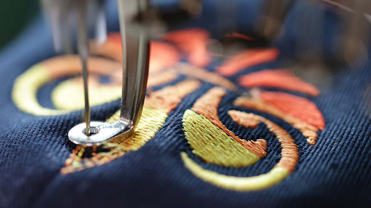 [Translate to Global Spanisch:] Madeira Coloreel embroidery thread stitching a yellow and red lily design 
