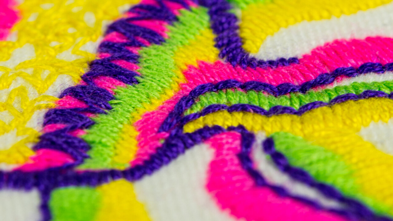 Close up of embroidery in yellow, green and pink colors