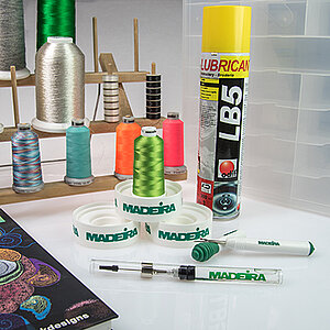 Accessoires de broderie comme la plaque conique, le spray adhésif, le carnet de perforations et plus encore.